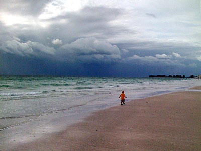 James walking along Holmes Beach under dramatic skies