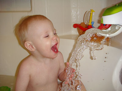 James attempting to drink water from the bathtub faucet