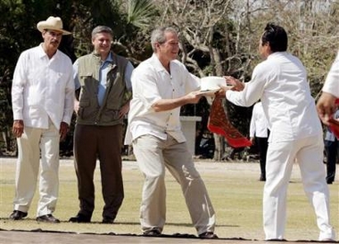 Bush tugs on Mexican dancer's hat as leaders of Mexico and Canada look on